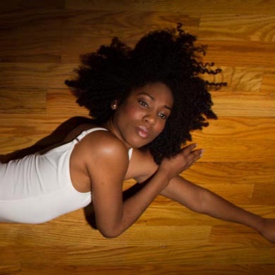 Weslyn Stephens laying on wooden floor, looking up at camera